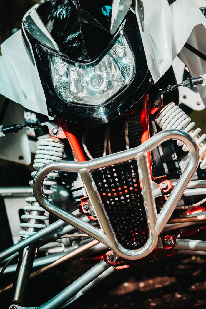 Close-up of an off-road quad bike front view featuring headlights and suspension.